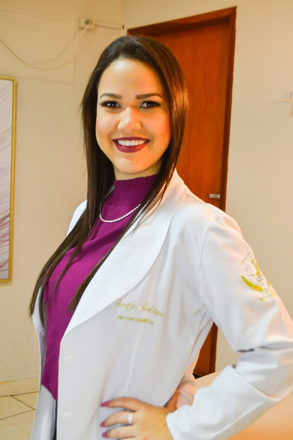 Jheniffer Rodrigues sorrindo, de jaleco